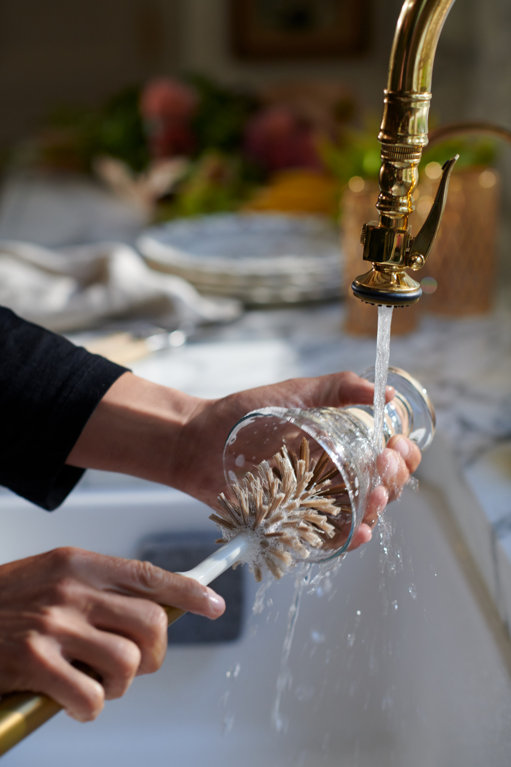 Person cleaning bottle with Curio Homegoods Brass Ionic Bottle Brush