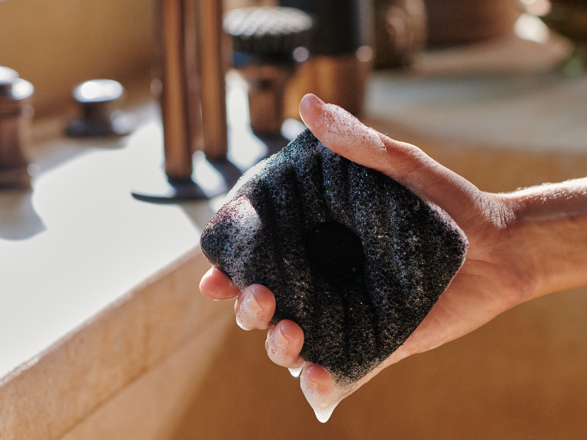 Person washing dishes with Curio Homegoods Ionic Counter Sponge in kitchen sink