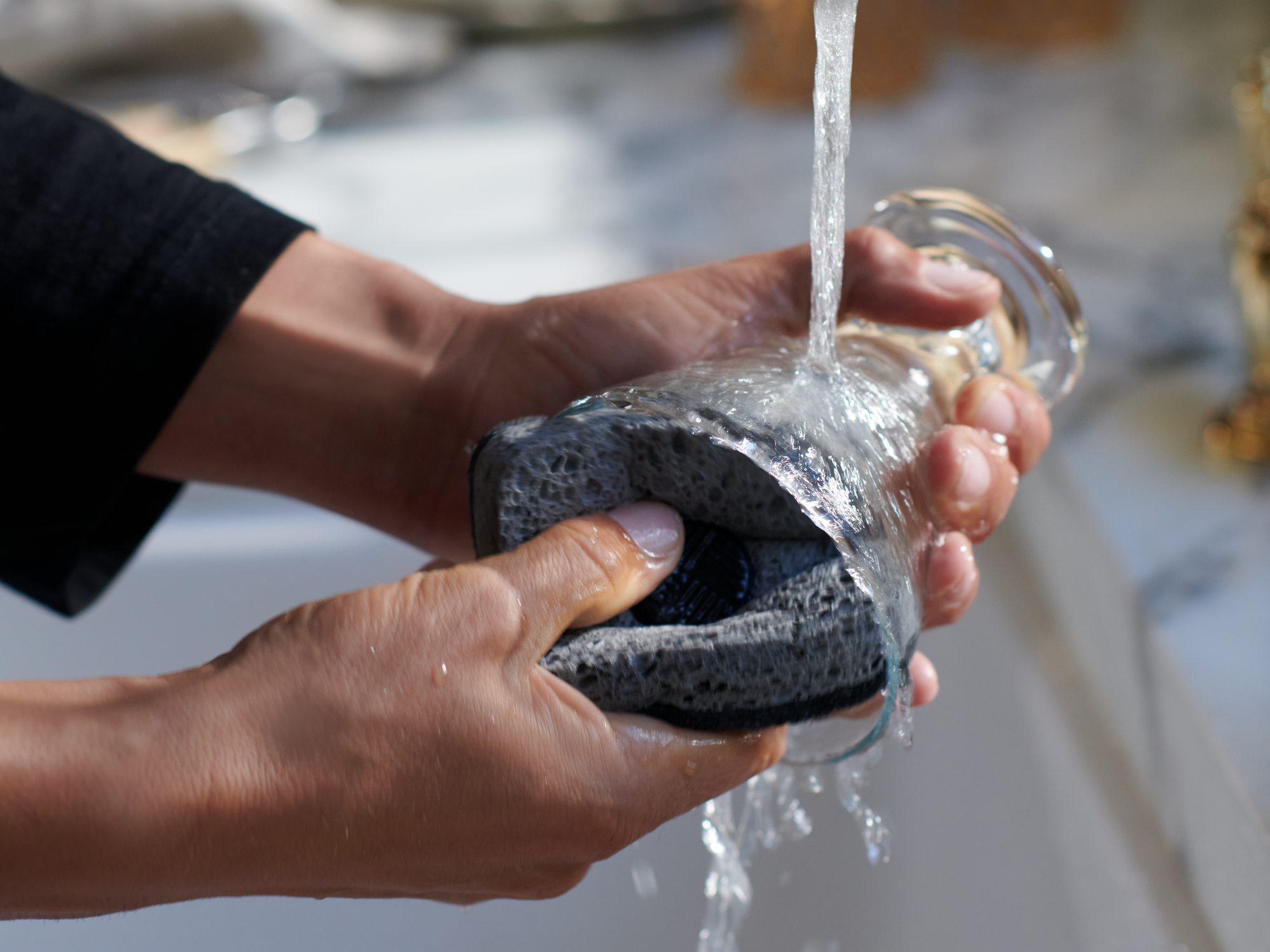 Person washing dishes with Curio Homegoods Ionic Counter Sponge 