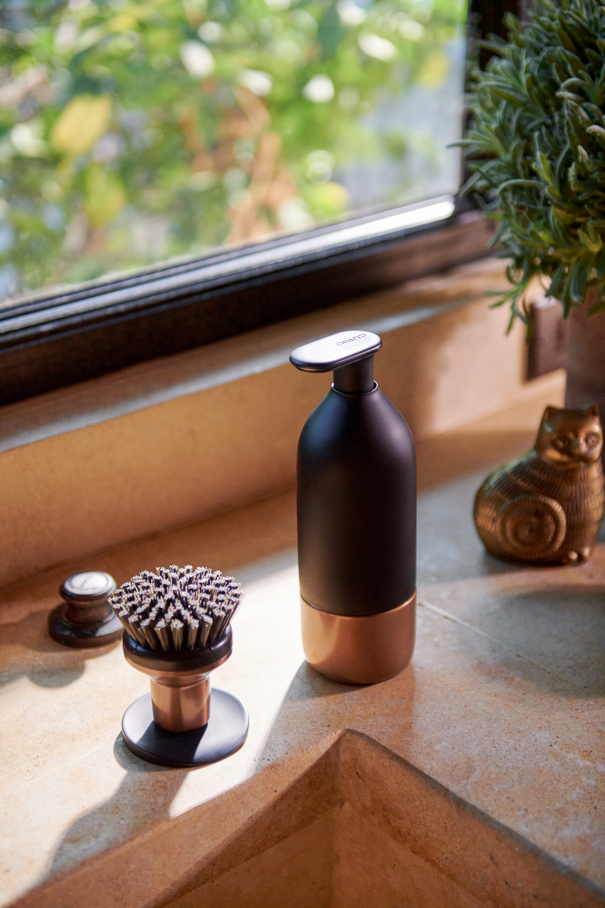 Curio Homegoods Ionic Palm Brush in Bronze standing on kitchen counter