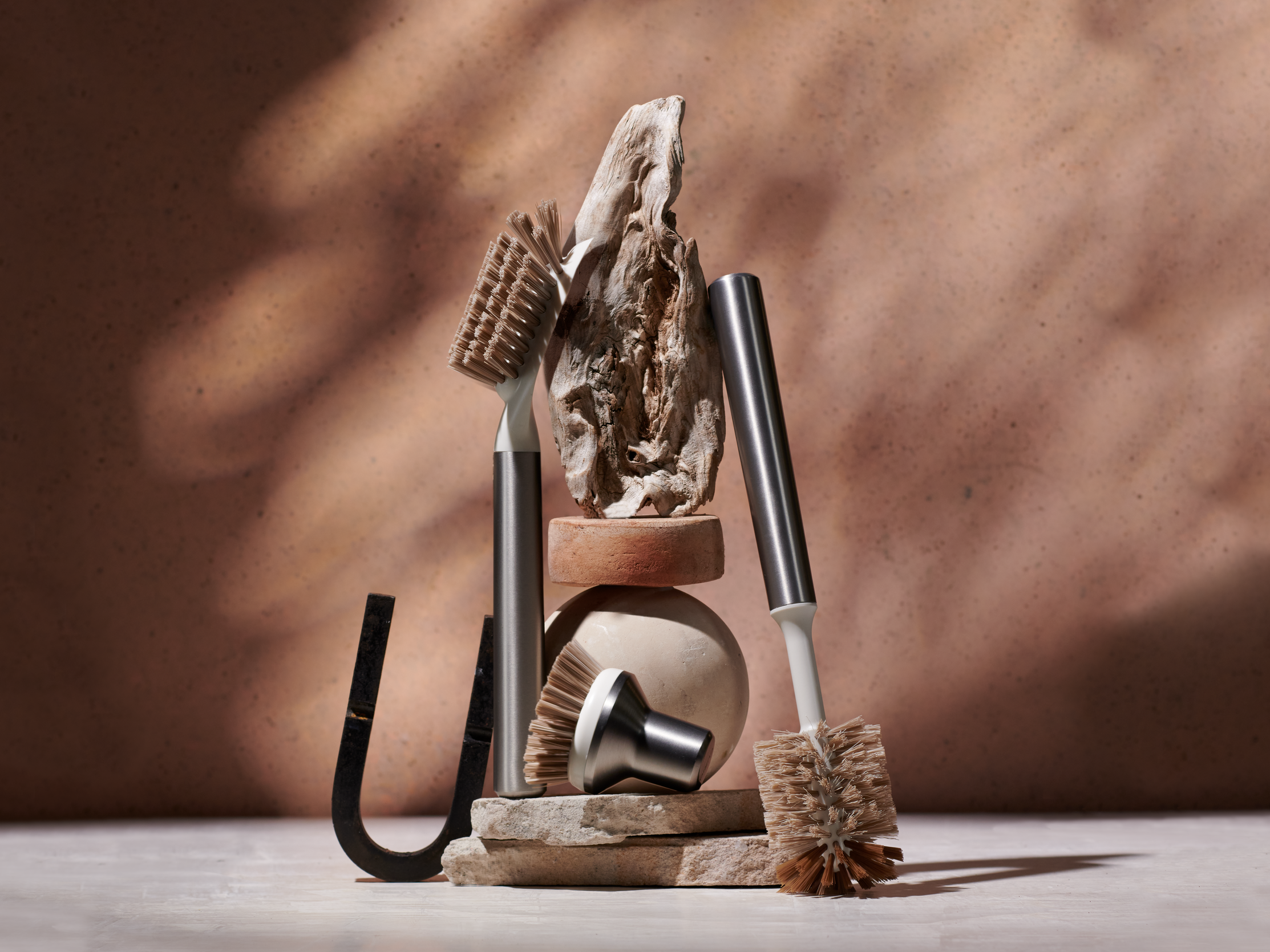 Curio Homegoods Stainless Steel Ionic Brush Set among rocks