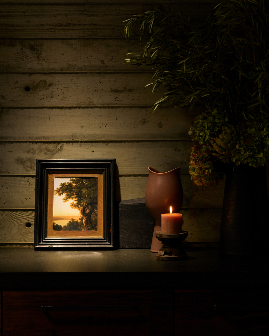 Dark kitchen counter with candle and painting 